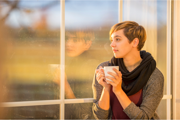 Girl reflecting in window with coffee cup